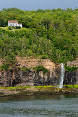 Fototapeta na wymiar Lone house above waterfalls at Digby Gut on the North Peninsula of Annapois Basin Nova Scotia