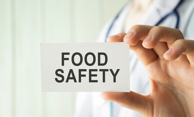 Doctor holding a card with text Food Safety, medical concept