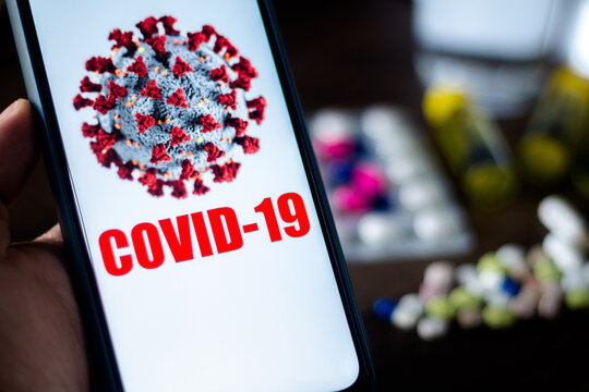 In this photo illustration pharmaceutical pills are seen displayed on a table with a COVID-19 inscription on the mobile screen. Dexamethasone, Hydroxychloroquine are used to treat coronavirus disease.