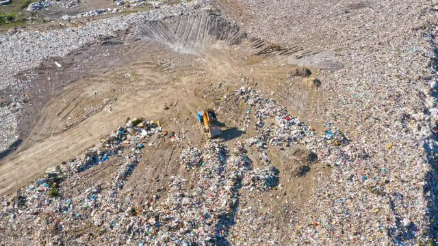Garbage trucks unload garbage in a city landfill. Aerial view. Earth pollution and environmental disaster concept