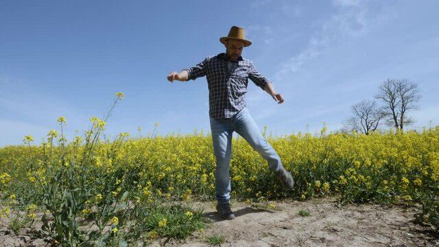 Happy Man Farmer Dancing Enjoying at Rape Blossom On Field. Fun Celebrating Funny Viral Dance Freedom. Guy Enjoying Dance. Joyful Man Farmer Dancing. Slow Motion. Flowering Rapeseed Field Blue Sky.