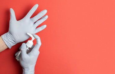 Medical background red. Medical antibacterial sanitizer gel and lab gloves on Virus protection equipment background. Clear sanitizer in pump bottle. Novel Coronavirus 2019-nCoV