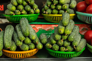 Green cucumbers on the market in baskets for sale.