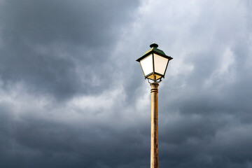 Candeeiro acesso em dia com céu cinzento com nuvens