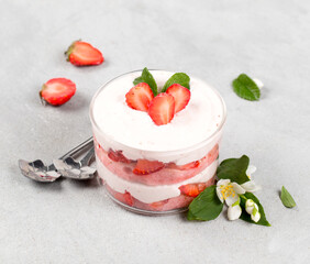 Tiramisu cream strawberry dessert in a glass Cup on a light background