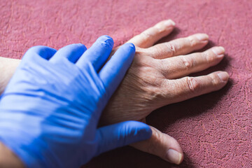 Fototapeta premium gloved hand on old man's hand