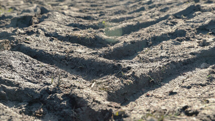 Close up tractor deep track traces. Dirty road with slop
