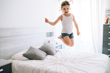 girl jumping on the bed fun