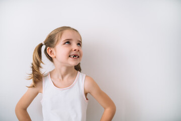 portrait of toothless blonde girl thinking on a white background