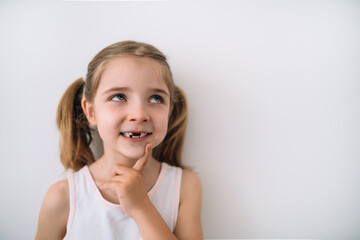 portrait of toothless blonde girl thinking on a white background