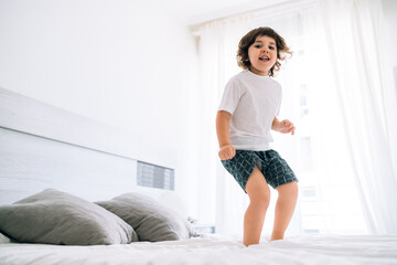child jumping on the bed in a fun way