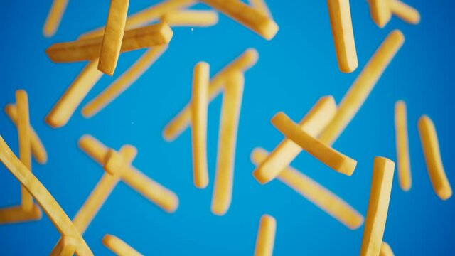 French fries falling and floating against a blue background