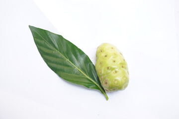 Fruits of Noni with green leafs isolated on white background. Great morinda. Indian mulbery. Beach mulbery. Morinda citrifolia.   