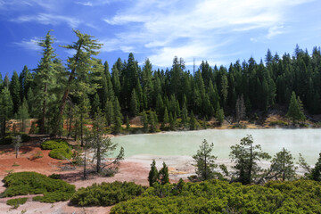 green hydrothermal lake surrounded by forest in Bumpass Hell in Lassen Volcanic National Park