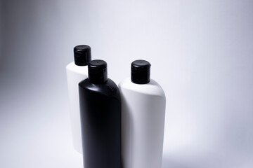 Composition of three white and black shampoo bottles with no label. body care and beauty concept. Copy space. . High quality photo