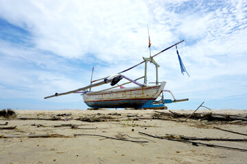 Fototapeta na wymiar Sailboat on the sand, sailboat lie on the beach waiting for a sailor. 