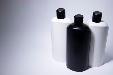 Composition of three white and black shampoo bottles with no label. body care and beauty concept. Copy space. . High quality photo