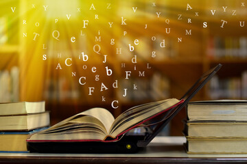 Open book on the table and English alphabet Floating above the book in the library and blur...