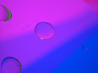 Closeup blue purple oil bubbles with colorful background and blurred ,macro image ,sweet color ,rainbow and colorful balloons background, abstract background