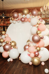 Children's photo zone with a lot of balloons. Decorations for a One year old Girls Birthday party. Concept of children's birthday party. Cubes with the word one and cream-colored and pink balls