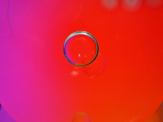 Closeup red oil bubbles with colorful background and blurred droplets ,macro image ,sweet pastel color ,rainbow and colorful balloons background, abstract background