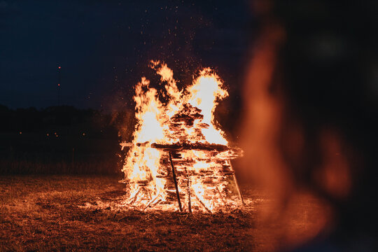 Woman watching midsummer holidays night fire in Latvia