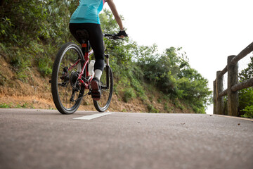 Fototapeta na wymiar Woman riding bike on sunny mountain trail