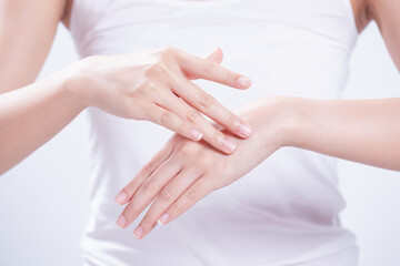 Fototapeta na wymiar closeup of female hands applying hand cream,Lotion