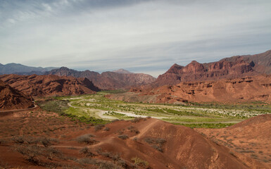 Panorama view of the valley and desert with red mountains and rocky formations. 