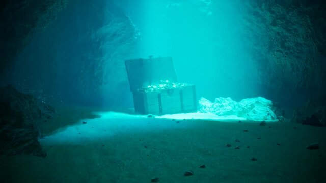 A treasure on the seabed in a secret underwater cave. Pirate chest in blue water