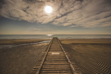 Wooden pier in the morning sun, beach of Lido Di Jesolo, Italy