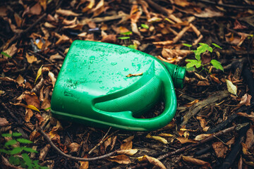 Plastic canister in autumn forest. Toxins into nature everywhere. Jerrycan in park among fallen...