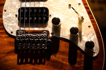 Detail of an electric guitar body with pickups, strings and buttons