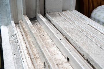 dirty dust piled up in plastic window frames.