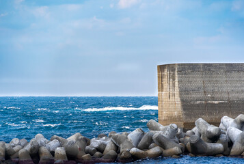 Fototapeta premium Wave in a winter sea and breakwater in Yamaguchi prefecture, JAPAN.