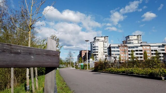 Hyperlapse: low angle view of people, bikes and dogs walking on asphalt urban walkway in Partille, Vastra Gotaland, Sweden
