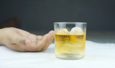 Concept of Withdrawal Symptoms from alcohol or Alcoholic diseases.Hand with a glass of whiskey on wood.
