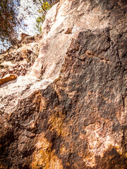 Natural background. Closeup edged shabby cliff cracks. Gray-brown stone rock texture of mountains. Vintage and faded matt style colour in tinted photo. Concept of geolog, mountaineering or hard work