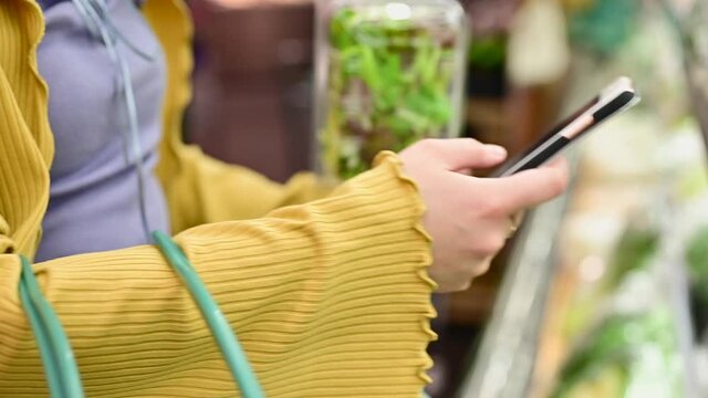 トレーサビリティで野菜の生産情報を確認する女性