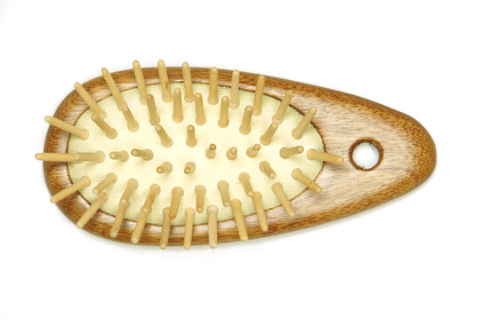 Small wooden hairbrush isolated on white background. Hand held antistatic comb. Top view.