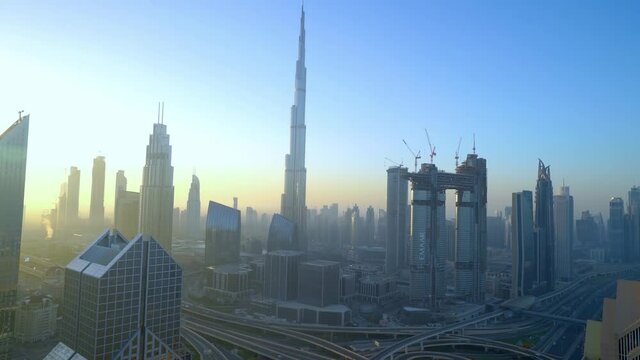 Dubai Skyline With The Famous Burj Khalifa And Sheikh Zayed Road From The Rooftop of Shangri-la Hotel At Sunrise In Dubai, UAE.  - wide shot