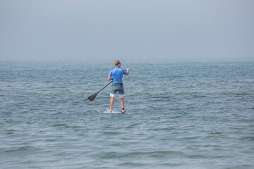 Fototapeta na wymiar Stand-up Paddle Boarder in Ocean