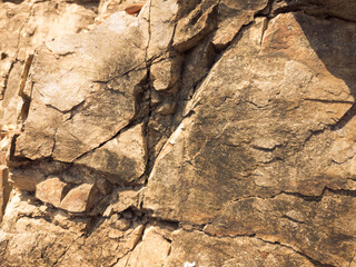 Natural background. Closeup edged shabby cliff cracks. Gray-brown stone rock texture of mountains. Vintage and faded matt style colour in tinted photo. Concept of geolog, mountaineering or hard work