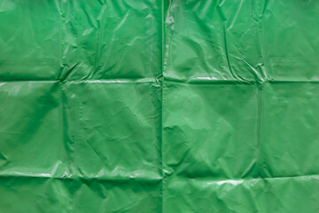 smooth and glossy texture of plain green vinyl canvas and folds