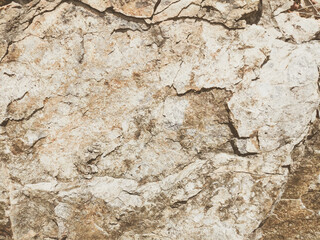 Natural background. Closeup edged shabby cliff cracks. Gray-brown stone rock texture of mountains. Vintage and faded matt style colour in tinted photo. Concept of geolog, mountaineering or hard work
