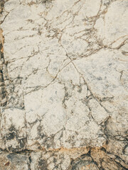 Natural background. Closeup edged shabby cliff cracks. Gray-brown stone rock texture of mountains. Vintage and faded matt style colour in tinted photo. Concept of geolog, mountaineering or hard work