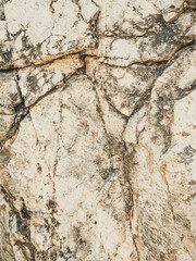 Natural background. Closeup edged shabby cliff cracks. Gray-brown stone rock texture of mountains. Vintage and faded matt style colour in tinted photo. Concept of geolog, mountaineering or hard work