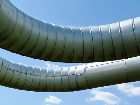 Overhead Steel Pipeline. Aluminum Shroud Covered Gas Or Heating Supply Tubes On Concrete Support. Blue Sky. Natural Gas Supply Shortage And Energy Supply Security Concept. Europe, Russia, Germany.