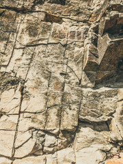 Natural background. Closeup edged shabby cliff cracks. Gray-brown stone rock texture of mountains. Vintage and faded matt style colour in tinted photo. Concept of geolog, mountaineering or hard work