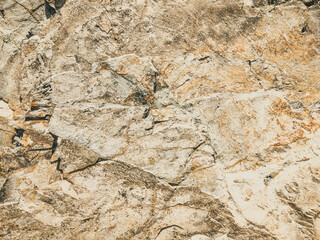 Natural background. Closeup edged shabby cliff cracks. Gray-brown stone rock texture of mountains. Vintage and faded matt style colour in tinted photo. Concept of geolog, mountaineering or hard work
